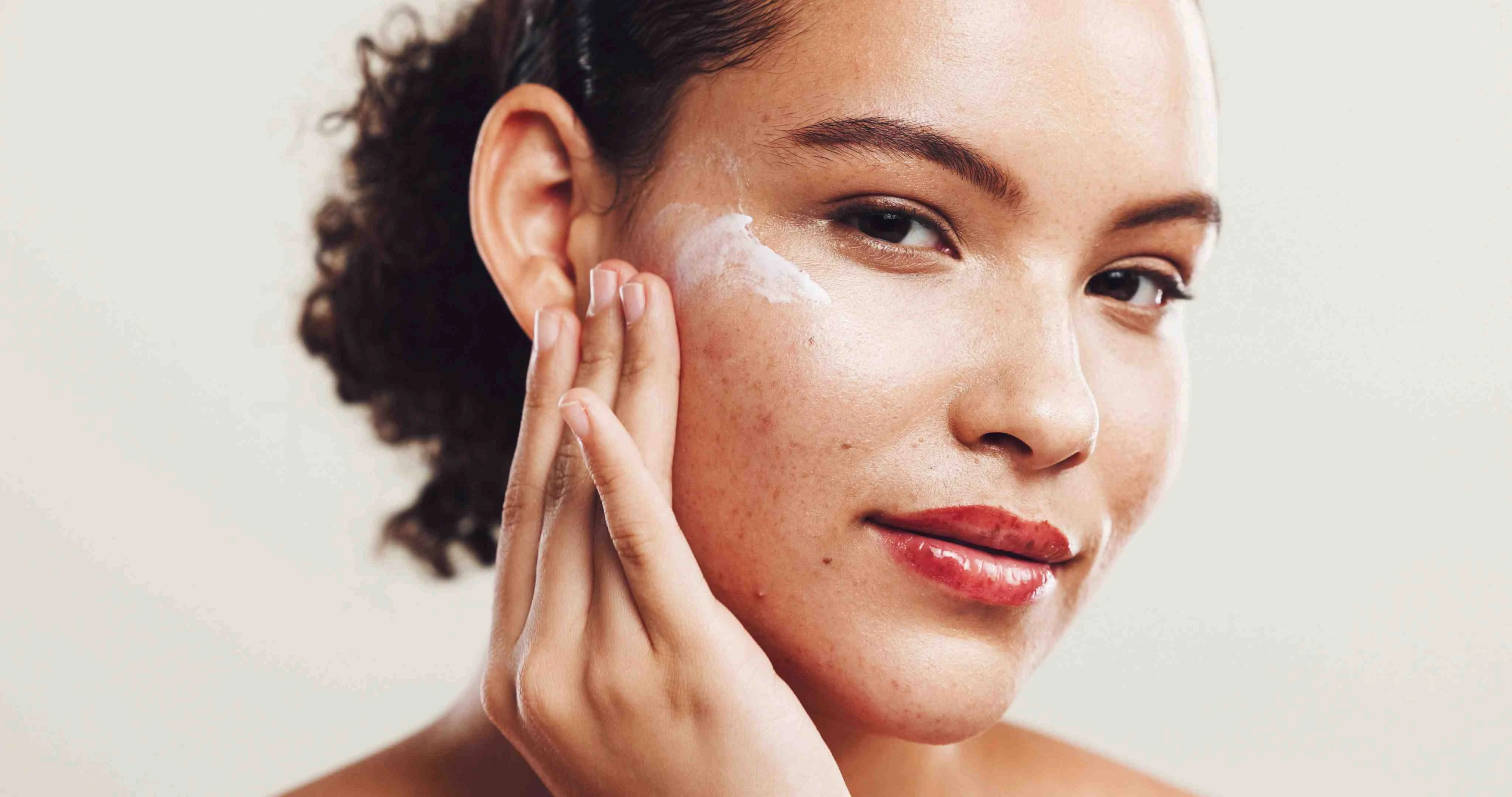 Femme prenant soin de sa peau, entourée de produits naturels et carnets de routines beauté SOPK